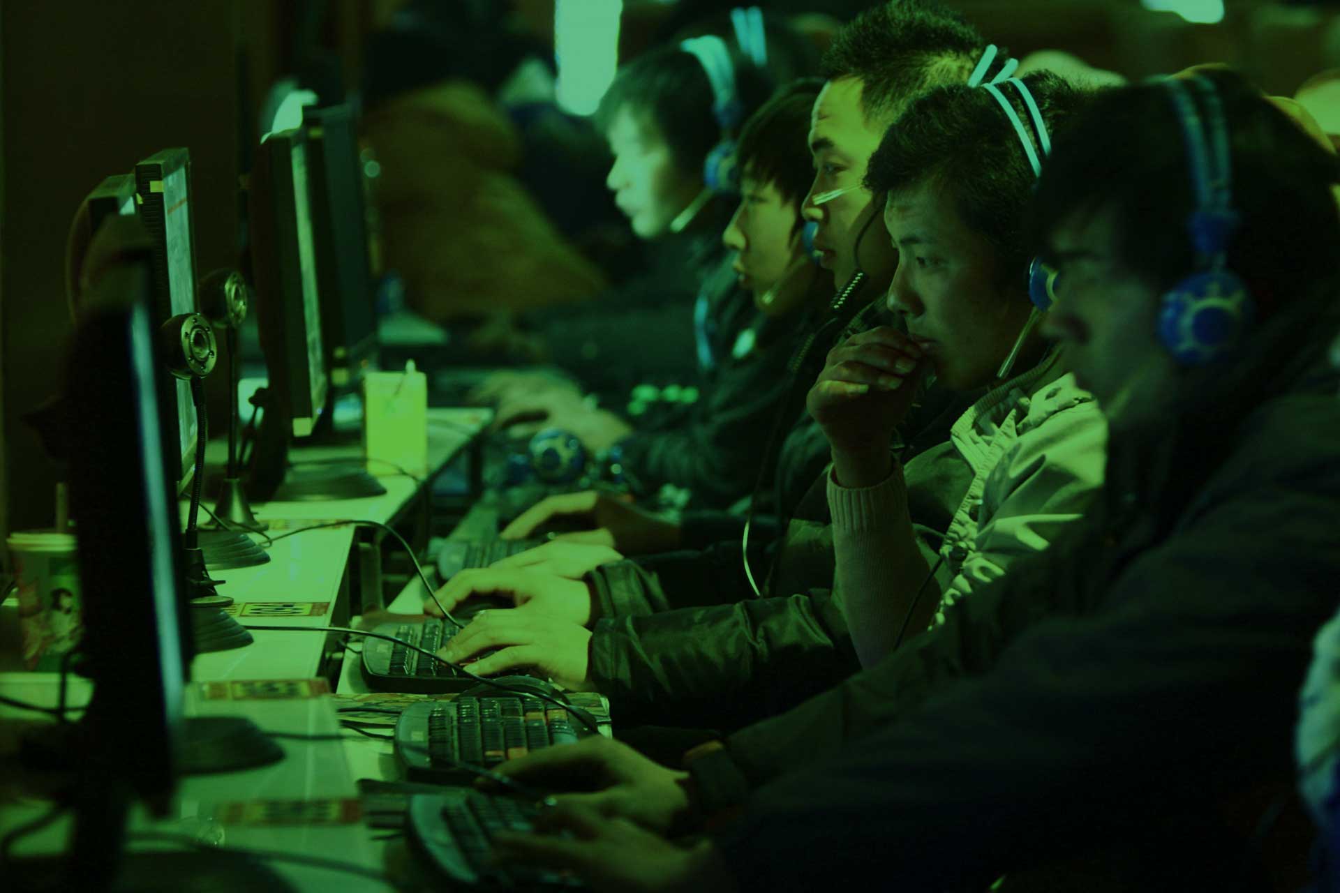 Players at a row of gaming PCs in an internet cafe